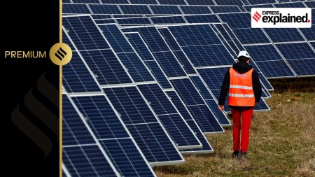 An employee walks past solar panels at the photovoltaic park installed by Engie in Marcoussis near Paris, France, February 12, 2024.