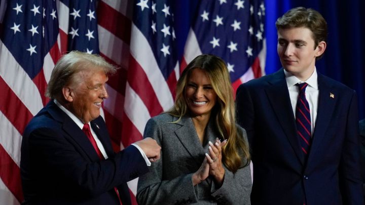 Republican presidential nominee former President Donald Trump dances on stage with former first lady Melania Trump, center, and son Barron Trump at an election night watch party.