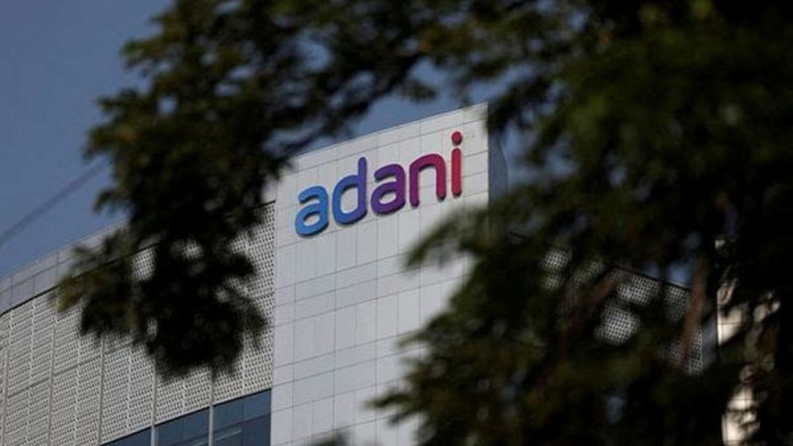 Moody's downgrades Adani firms; bribery allegations cited.