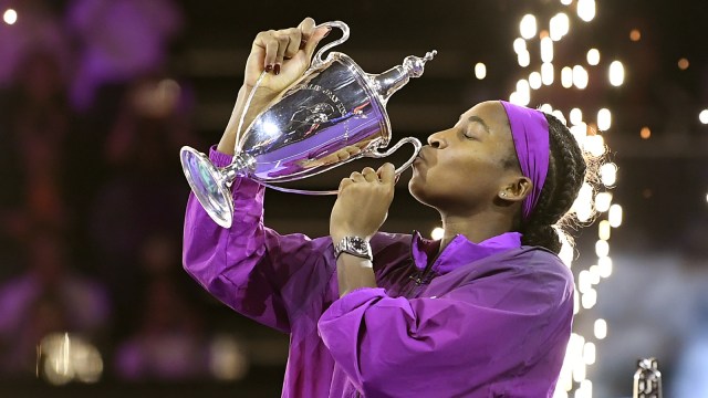 Coco Gauff of the U.S. kisses her trophy after winning against China's Qinwen Zheng in their women's singles final match of the WTA finals at the King Saud University Indoor Arena, in Riyadh, Saudi Arabia, Saturday, Nov. 9, 2024. (AP Photo)