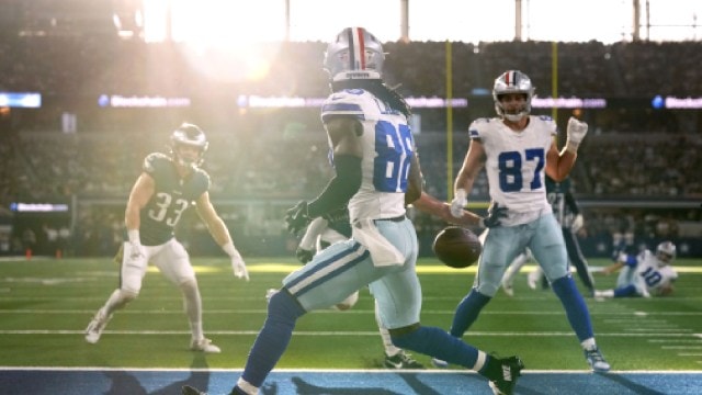 Dallas Cowboys wide receiver CeeDee Lamb runs past a pass thrown into the end zone by quarterback Cooper Rush as Philadelphia Eagles' Cooper DeJean (33) and Jake Ferguson (87) look on in the first half of an NFL football game in Arlington, Texas,