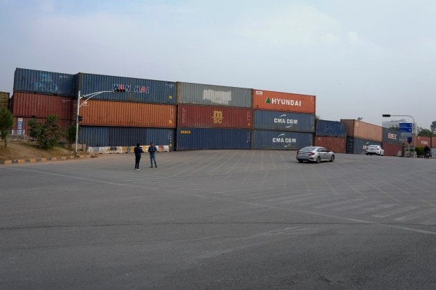 Vehicles use alternate way on road, which closed with shipping containers ahead of a planned rally by supporters of imprisoned former Prime Minister Imran Khan's Pakistan Tehreek-e-Insaf party, in Islamabad, Pakistan, Saturday, Nov. 23, 2024. (AP Photo/Anjum Naveed)