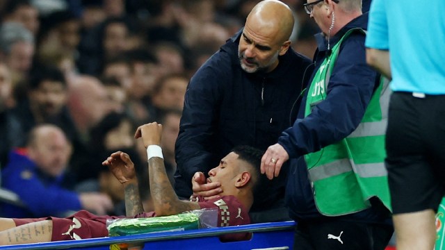 Manchester City's Savinho is carried distant  successful  a stretcher aft  sustaining an wounded   arsenic  Manchester City manager   Pep Guardiola looks on