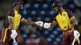 West Indies' Shai Hope, right, and Evin Lewis knock gloves during their partnership against England at the fourth T20 cricket match at Daren Sammy National Cricket Stadium in Gros Islet, St. Lucia