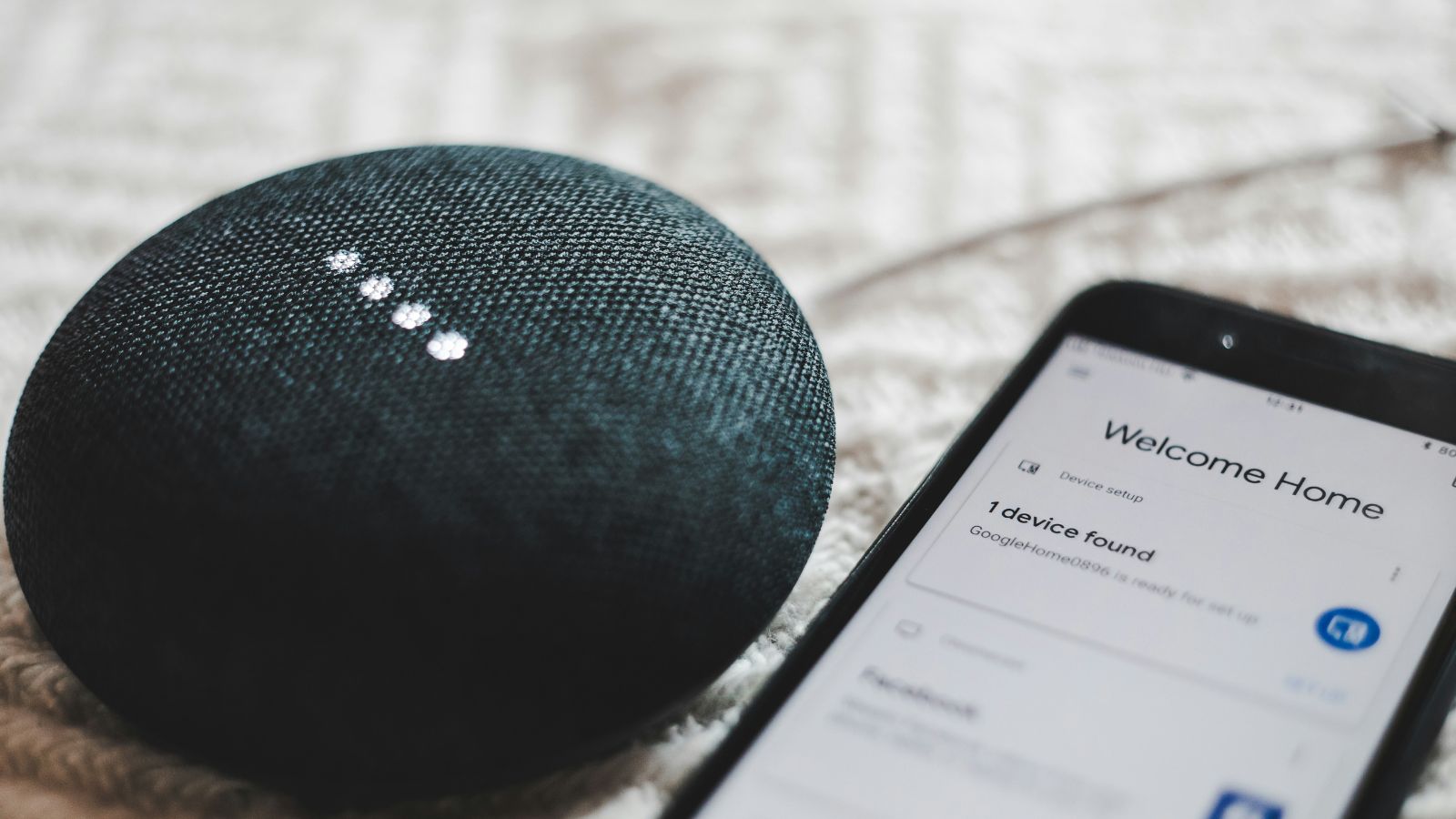 Google Home Mini placed next to a smartphone. (Image: Unsplash)