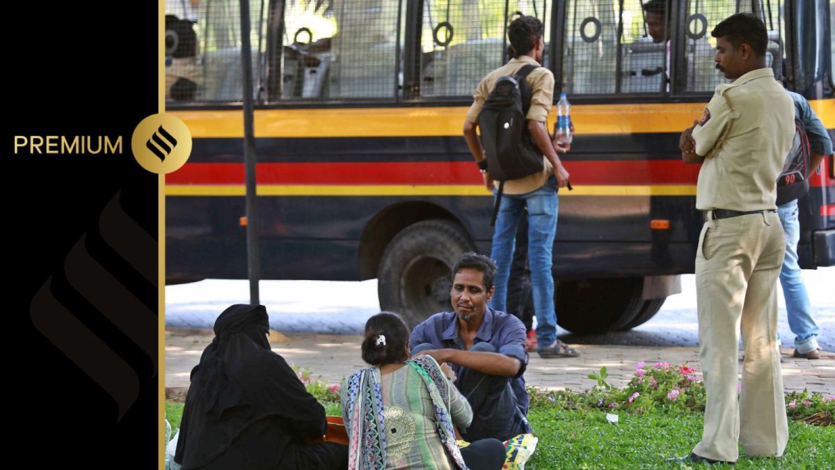 A police constable looks on as an undertrial prisoner speaks with his family members.