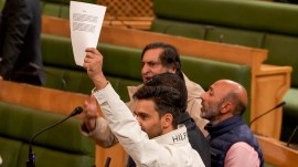 PDP MLA Waheed Para shows a copy of the resolution on Articles 370 and 35A, demanding its restoration, during the J&K Assembly session on Thursday. (PTI)