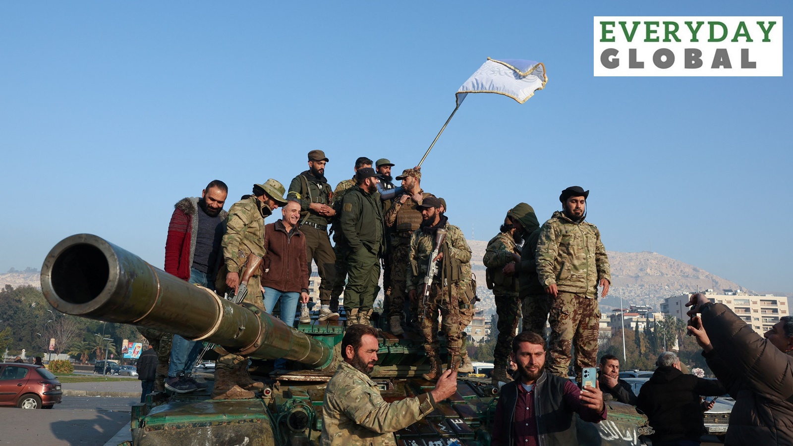 Rebel fighters stand on a tank, after rebels seized the capital and ousted President Bashar al-Assad, in Damascus, Syria, December 9, 2024.