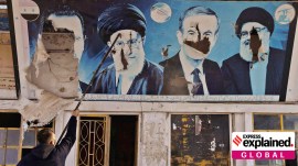 A worker tears down the pictures of Syria's Bashar al-Assad, former Syrian President Hafez al-Assad, Lebanon's late Hezbollah leader Sayyed Hassan Nasrallah and Iran's Supreme Leader Ayatollah Ali Khamenei in rural Aleppo, Syria, December 11, 2024.