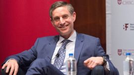 Michael Greenstone, Milton Friedman Distinguished Service Professor in Economics at the University of Chicago and Director of EPIC, sitting in a blue-gray suit against a red background pollution