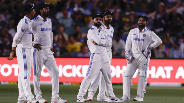 Indian players wait after the floodlights went off during the day one of the second cricket test match between Australia and India at the Adelaide Oval on Friday. (AP)