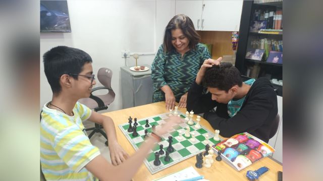 Mrunalini Kunte with students Shivam Pethkar and Aarush Budjade (in jacket) at Kunte's Chess Academy on Friday. (Express Photo)