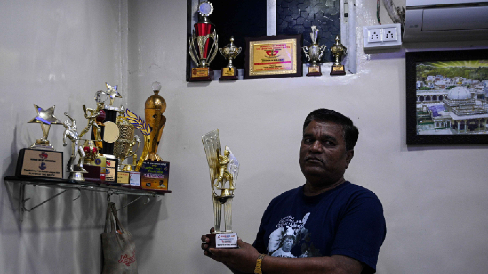 Simran Shaikh's father Jahid Ali shows off her trophies at their residence in Dharavi. (Express photo by Sankhadeep Banerjee)