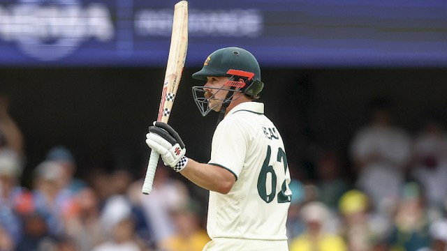 Travis Head raises his bat after scoring 150 runs during play on Day 2 of the third Test between India and Australia at the Gabba in Brisbane. (AP Photo)