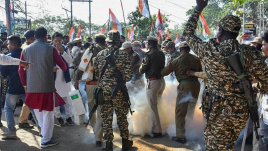 Police personnel use tear gas to disperse protestors during the Congress's 'Raj Bhavan Chalo' protest