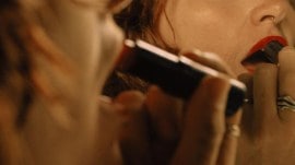 A person with facial hair applies lipstick in Italy in November 2024.Though studies suggest that almost half of all women will grow facial hair at some point in their lives, visible facial hair, whether that be a few bristles on a chin, a dark mustache or unruly eyebrows that meet in the middle, is not the norm culturally.