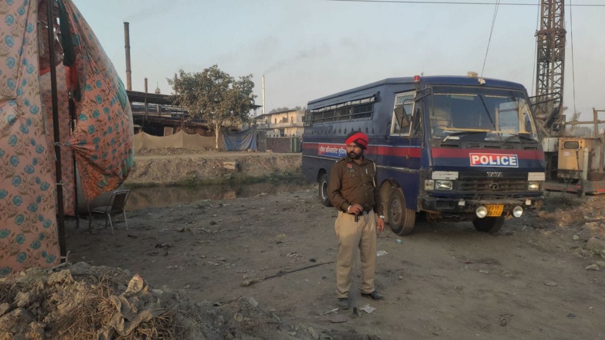 A police vehicle and personnel are stationed at the CETP, ahead of ‘Kale Pani da Morcha’ protest, at Buddha Nullah in Ludhiana, on Monday. Gurmeet Singh
