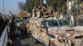 Rebel fighters sit on a vehicle, after seizing Damascus and ousting Bashar al-Assad. (Reuters) syria war