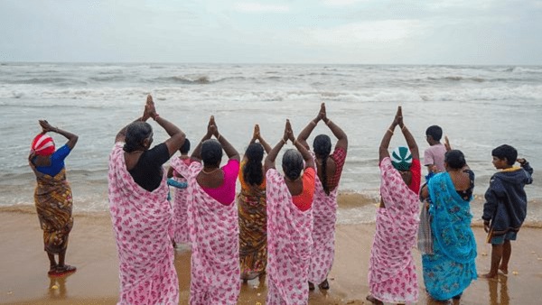 People from the fishing community pay tribute to the victims of the 2004 Indian Ocean tsunami during a ceremony, at Pattinapakkam Beach, in Chennai. 