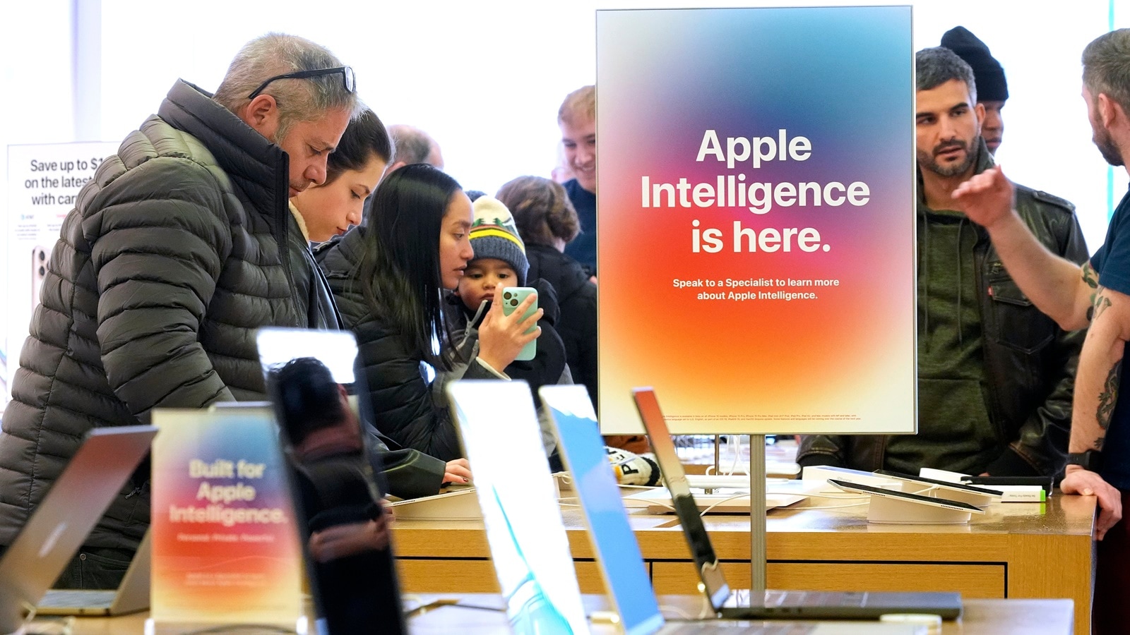 People gather around a table of iPhones at an Apple Store in US.
