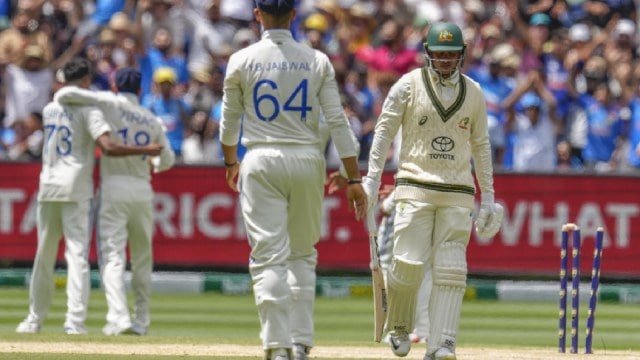 Usman Khawaja, right, walks off the field as Indian players celebrate his wicket during the fourth cricket Test between Australia and India at the Melbourne Cricket Ground. (AP Photo)