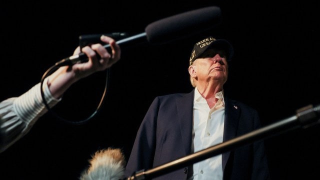 U.S. President Donald Trump looks on next to members of the press before boarding Air Force One as he departs for Las Vegas at Los Angeles International Airport in Los Angeles, California