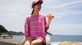 Woman eating pizza in the sun