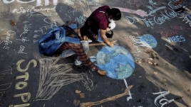 Students drawing street art for awareness on Climate change at Connaught Place in New Delhi on Sunday.