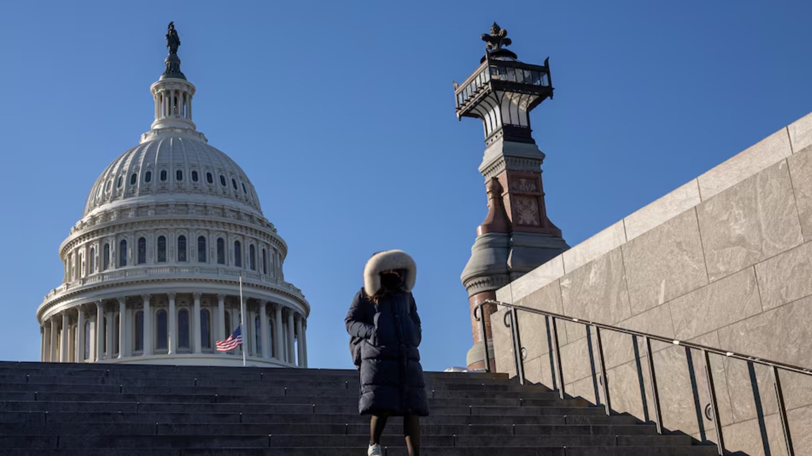 A woman walks down the stairs in front of the U.S. Capitol building. REUTERS/Marko Djurica