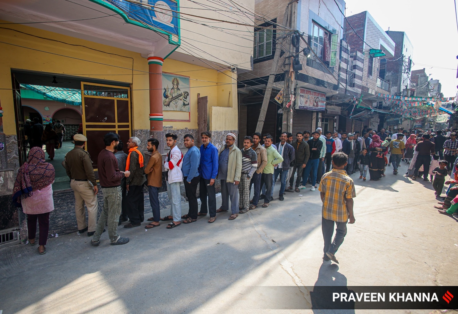People queue-up to vote outside a polling station in Delhi's Shiv Vihar, on Wednesday.