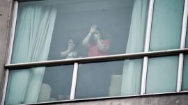 Migrants deported from the United States wave to the press from inside a hotel in Panama City, Wednesday, Feb. 19, 2025. (AP Photo)