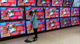 Finance Minister Nirmala Sitharaman is seen on television screens as she presents the Union Budget.