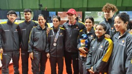 Coach DK Sen (red cap) with Uttarakhand badminton players at the National Games in Dehradun. (Credit: Express Photo)