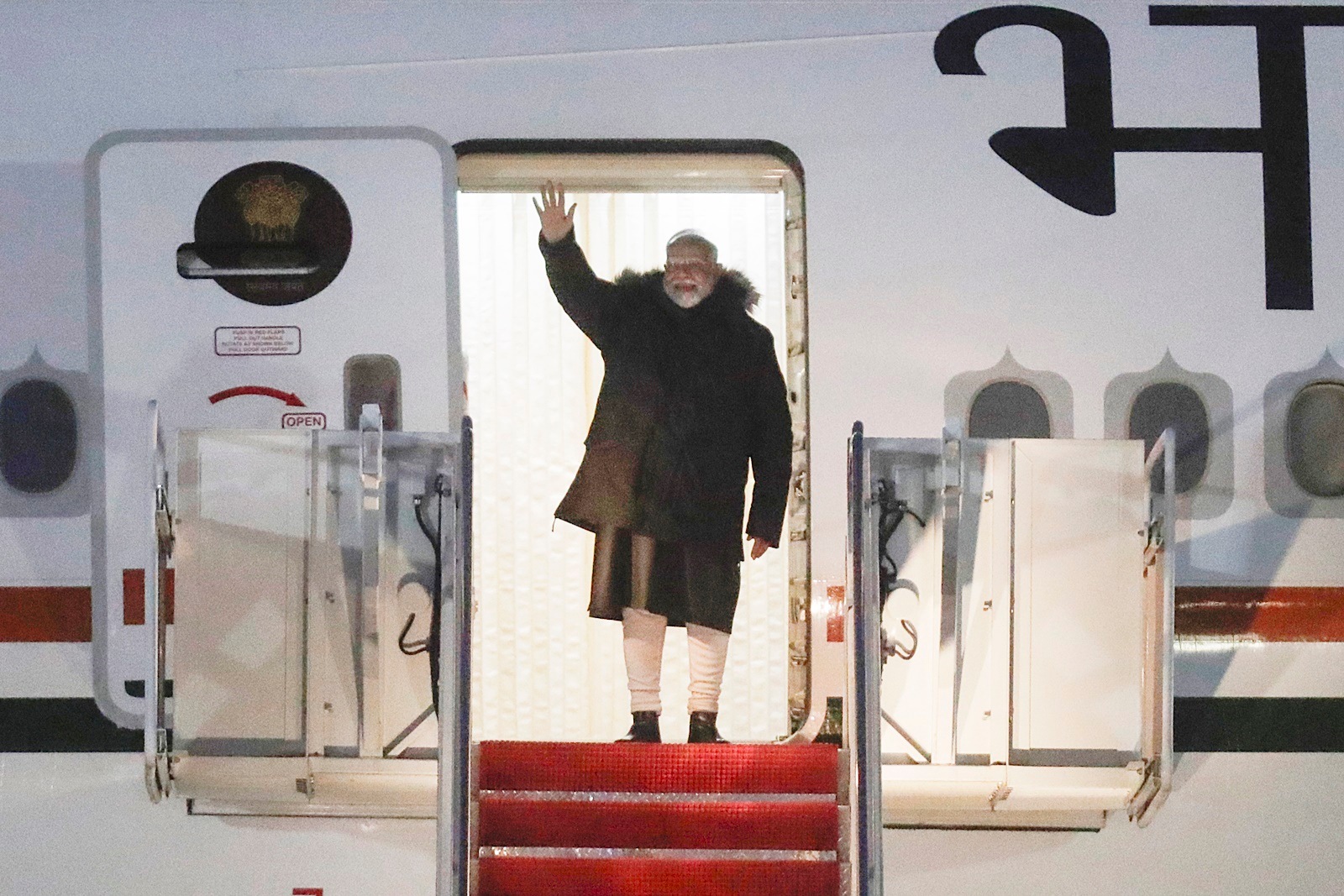 Prime Minister Narendra Modi waves from the stairs of his plane upon his arrival in the US
