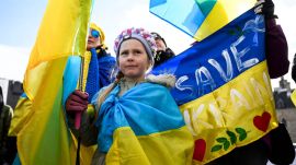 A youngster wears and holds Ukrainian flags during a rally on Parliament Hill to mark the 3rd anniversary of Russia's full-scale invasion of Ukraine, in Ottawa, Canada. (AP Photo)