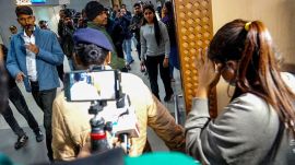 Mediapersons surrounding a deported person as she walked out of the Ahmedabad airport earlier this week (Express Photo/Bhupendra Rana)
