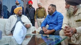 Punjab Minister for NRI affairs Kuldeep Singh Dhaliwal meets Daler Singh, in blue, one of the Indian immigrants deported from the US, at his residence in Salempur village of Amritsar, on Thursday. (PTI Photo)