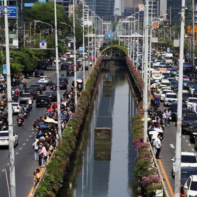 People stand on the road as cars are stuck in traffic after a strong earthquake struck central Myanmar