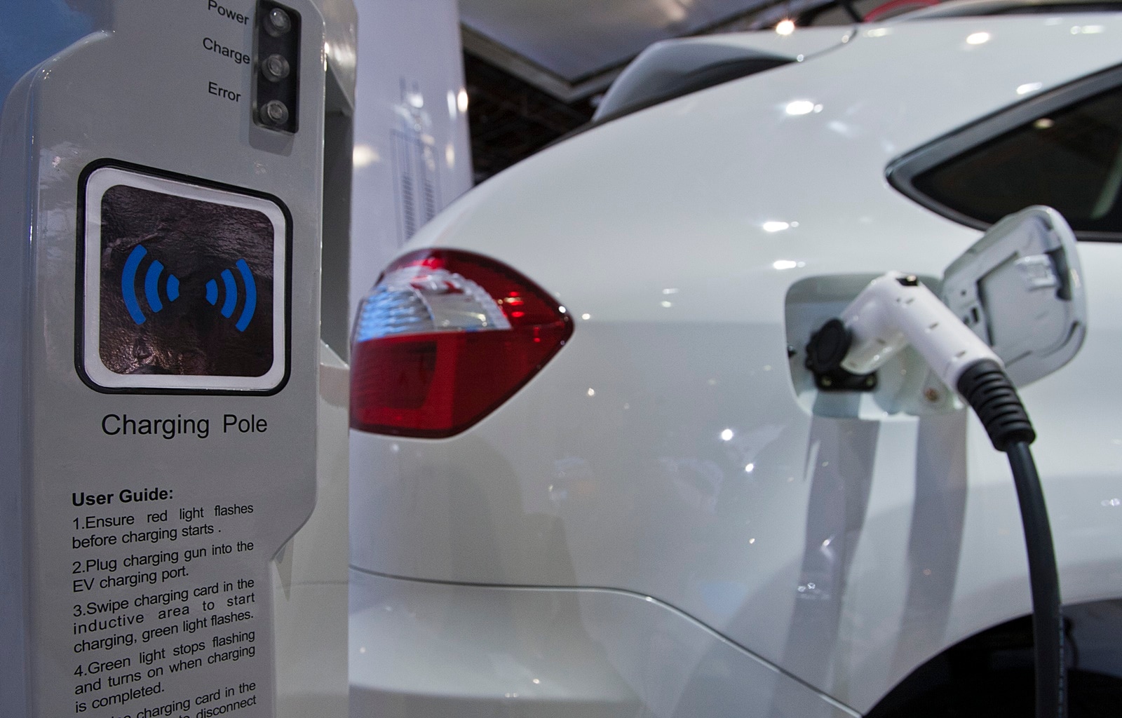 A display shows how the dual-mode electric S6DM sport utility vehicle from Chinese automaker BYD can be plugged into a charging station to recharge its onboard batteries
