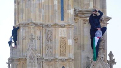 A man with a Palestine flag after he climbed up Elizabeth Tower, which houses Big Ben at the Palace of Westminster in London. Saturday, March 8, 2025. (James Manning/PA via AP)