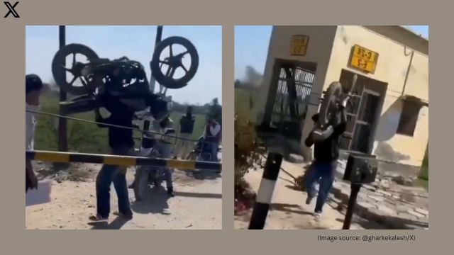 Man lifted his bike on his shoulders to cross the railway barrier