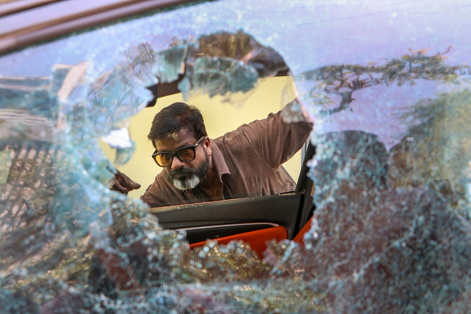 A local looks at a vandalised car, a day after violence broke out in Nagpur on Tuesday