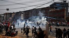Pro-monarchist protesters run for cover as riot police personnel fired tear gas shells to disperse the crowd during the protest demanding the restoration of Nepal's monarchy, which was abolished in 2008, saying the governments have failed to make any significant changes, in Kathmandu, Nepal, March 28, 2025. REUTERS/Navesh Chitrakar