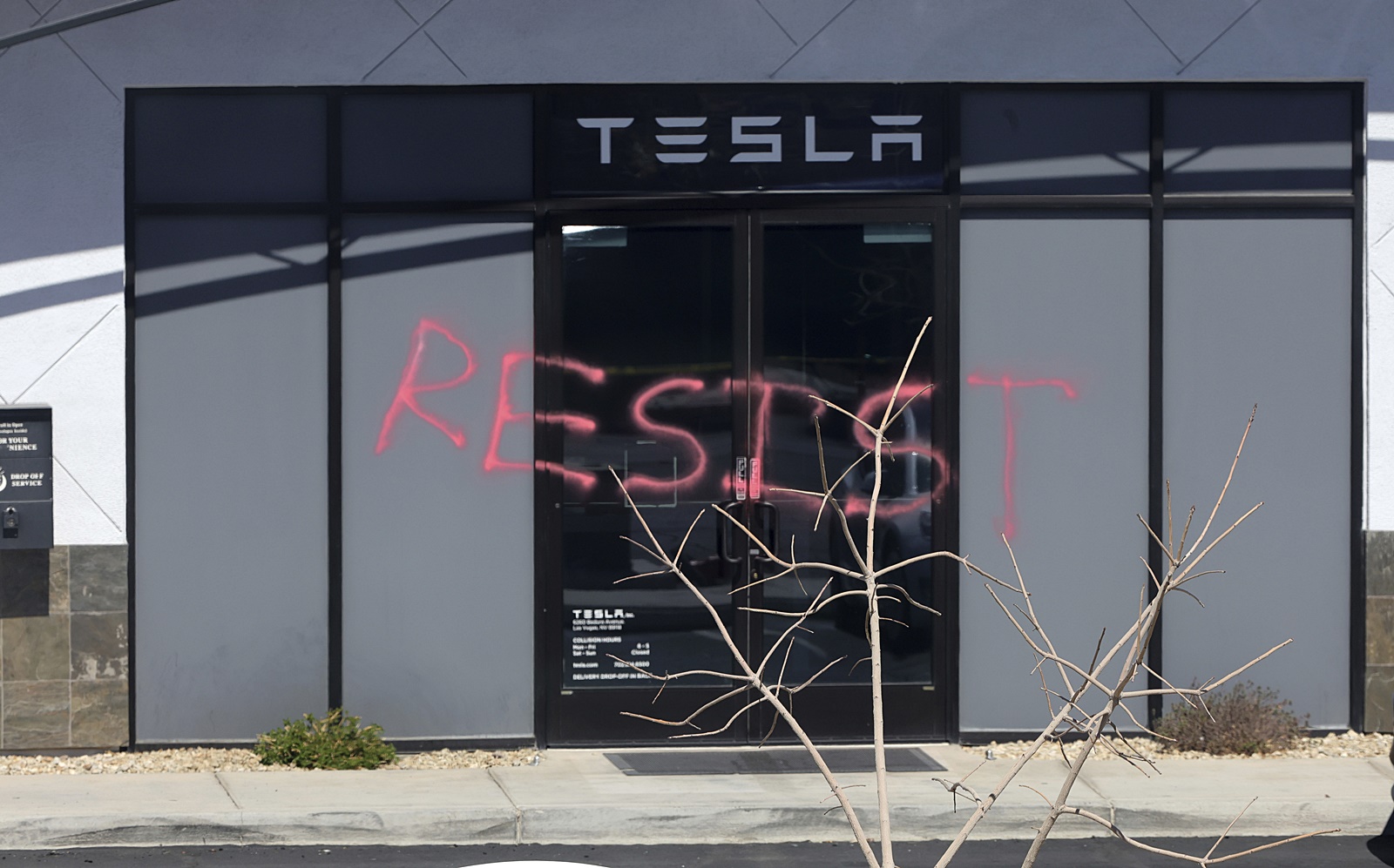 "Resist" is spray painted on the doors of a Tesla collision center in the 6000 block of West Badura Avenue on Tuesday in Las Vegas