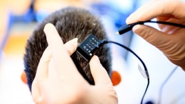 Researchers connect Ann's brain implant to the voice synthesizer computer. (Photo by Noah Berger)