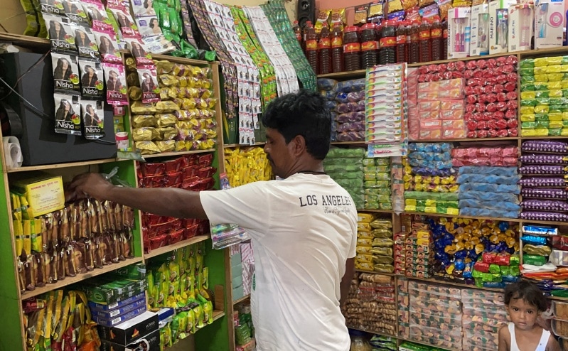 A store owner arranges consumer products in Uttar Pradesh (Reuters)