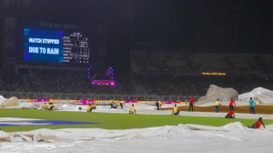 The ground staff at the Eden Gardens in Kolkata try to prevent the covers from blowing off in the face of strong gusts of wind. (Express Photo by Partha Paul)