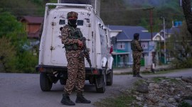Security personnel stand guard on a highway in south Kashmir after militants killed tourists in Pahalgam on Tuesday