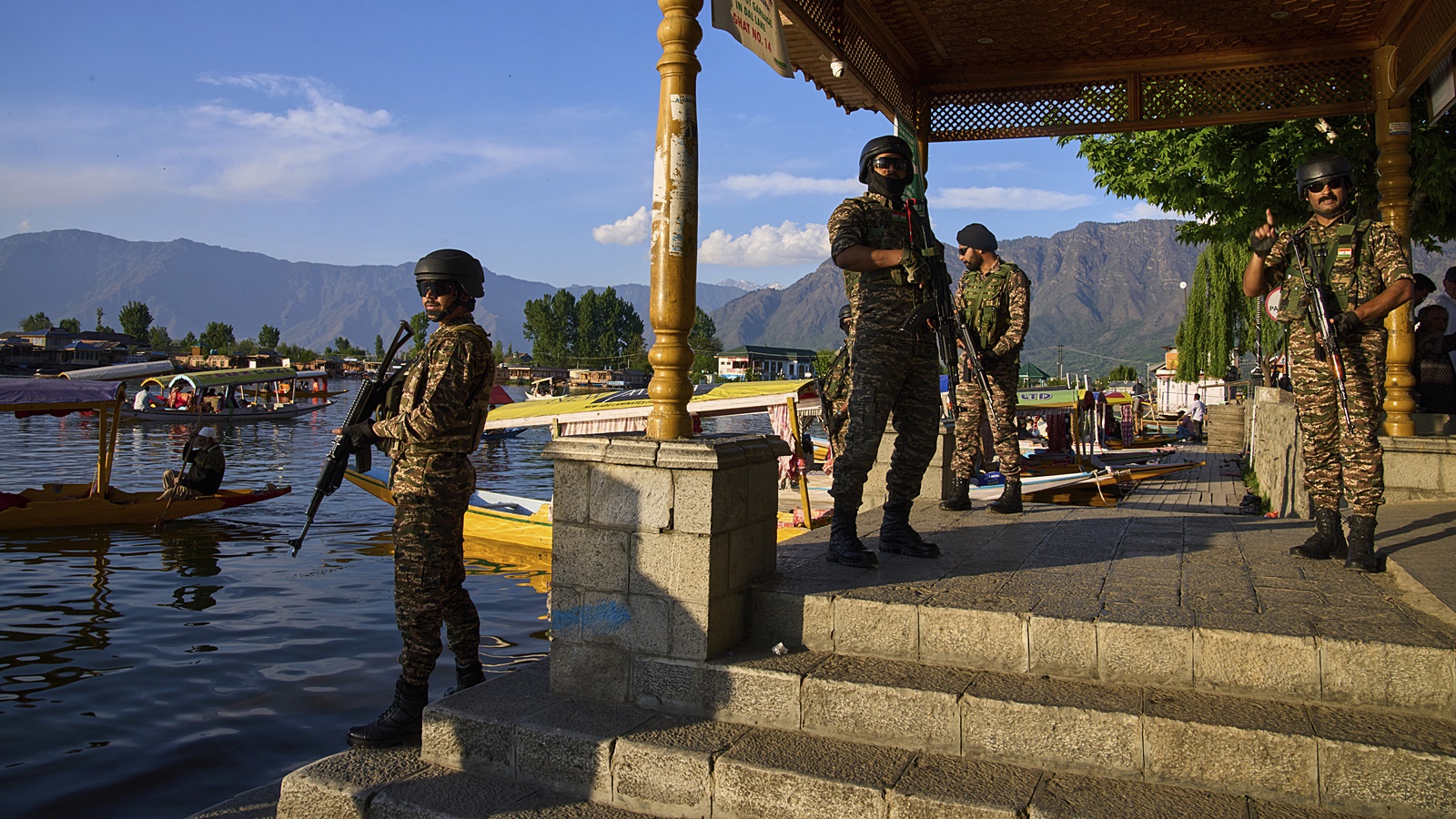 Paramilitary soldiers stand guard at the banks of Dal Lake as tourists take boat rides in Srinagar on Friday. Security has been steeped up in the region following the Pahalgam attack,