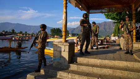 Paramilitary soldiers stand guard at the banks of Dal Lake as tourists take boat rides in Srinagar on Friday. Security has been steeped up in the region following the Pahalgam attack,